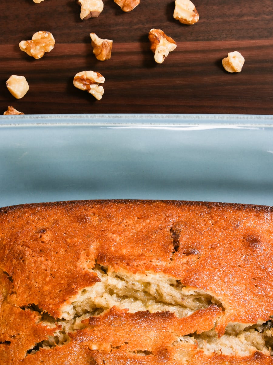 top view of a table decorated with walnuts and with a large platter of banana bread