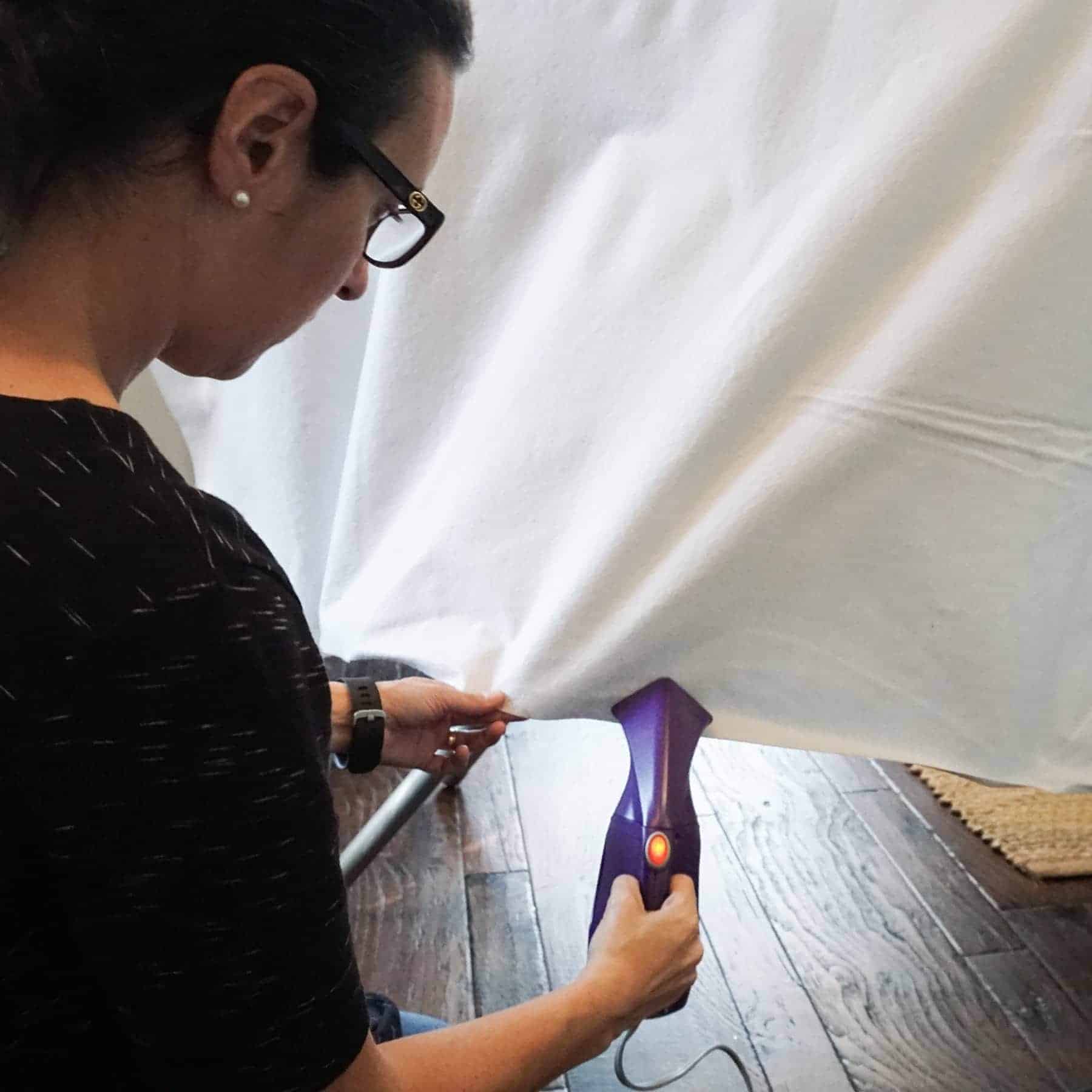 steaming out wrinkles from a tablecloth using a mini steamer