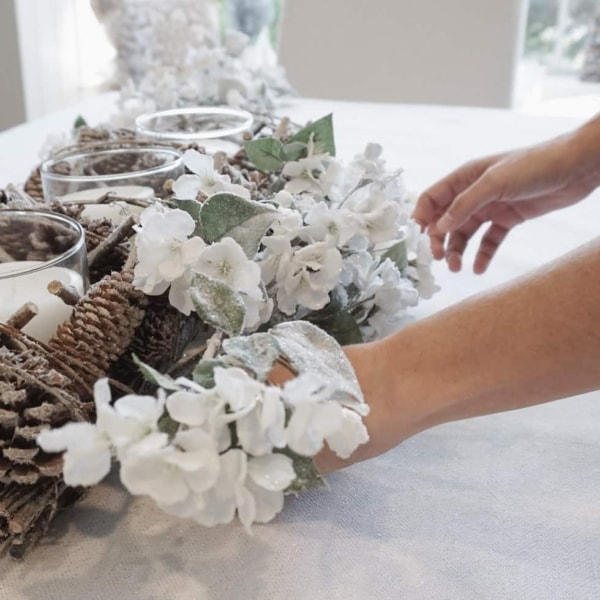 Setting up a dining room table centerpiece for Christmas.