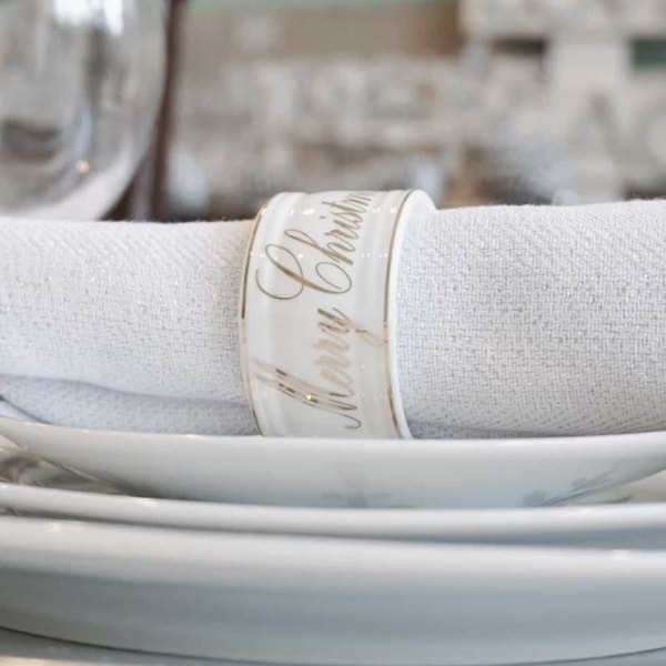 stacked christmas plates with a napkin and napkin ring on top
