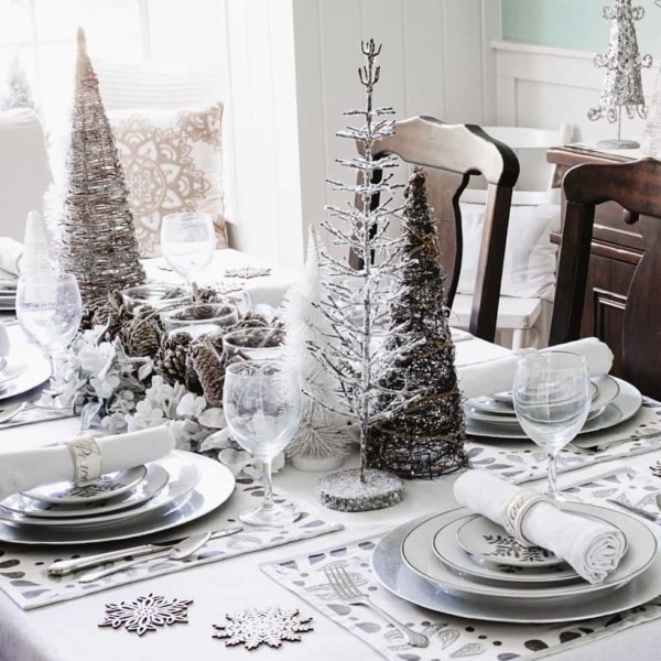 A beautiful Christmas dining room table with a sparkly table cloth, muted decor with silver and frosted accents.