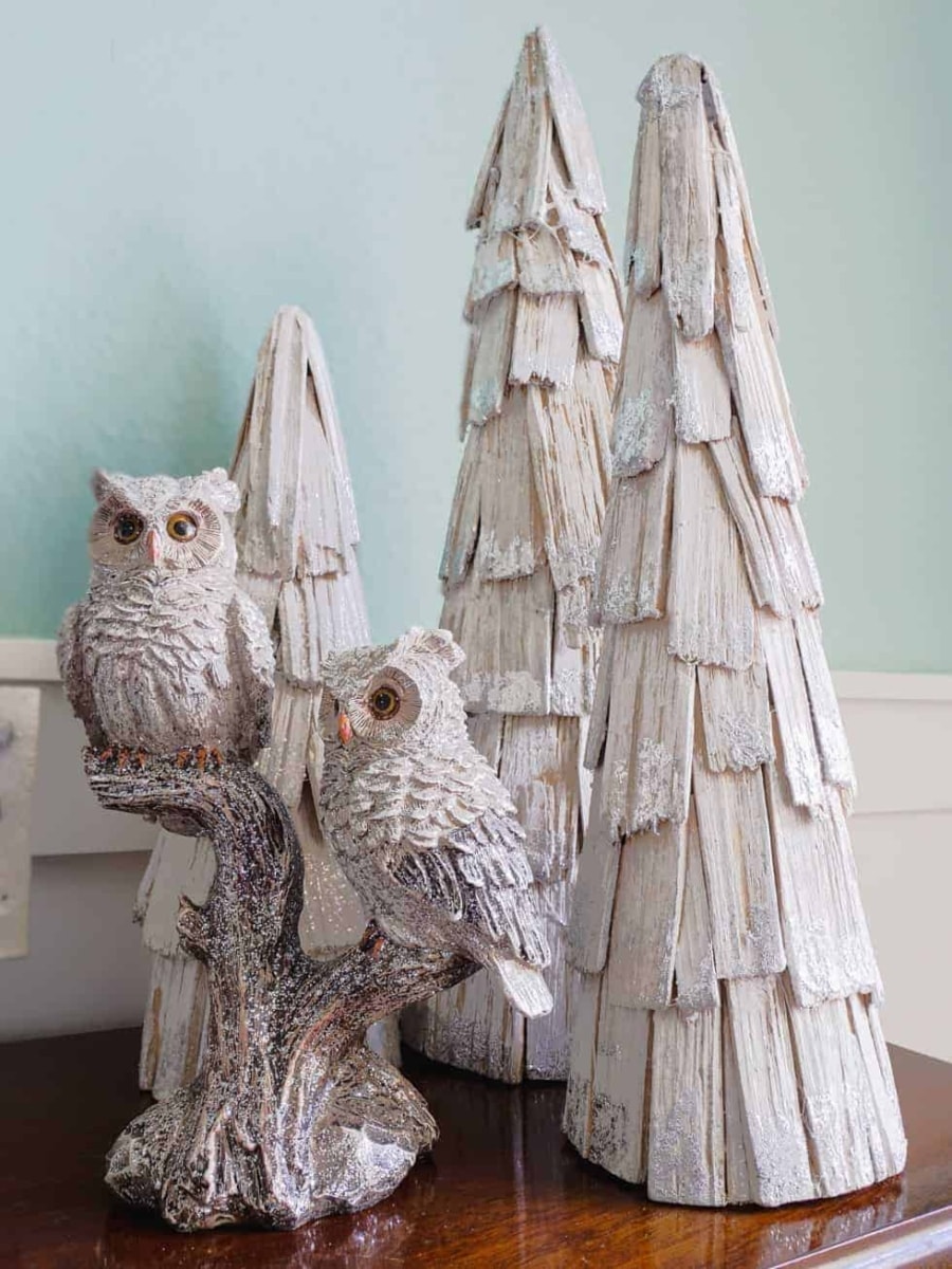 Decorative wood owls and white washed wood trees.