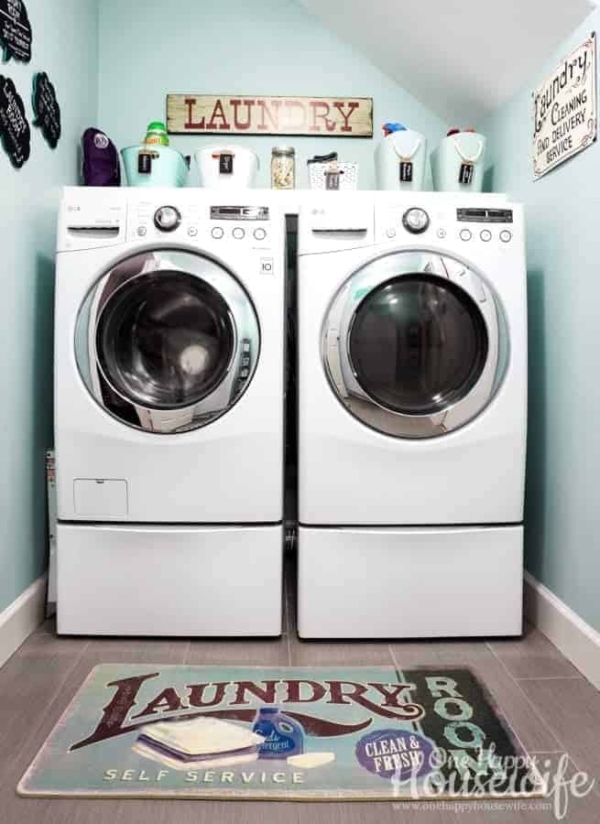 A super clean and organized laundry room with white front load washer and dry.