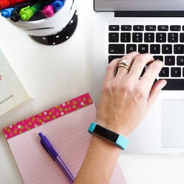 typing on a computer next to a book titled the life-changing magic of tidying up