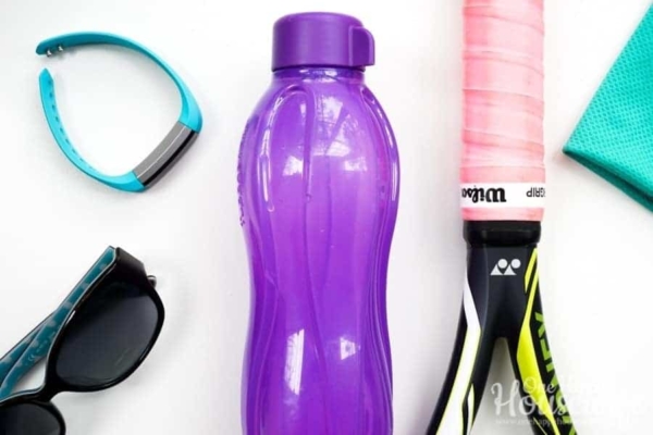 fitbit, water bottle, sunglasses, tennis racket, towel