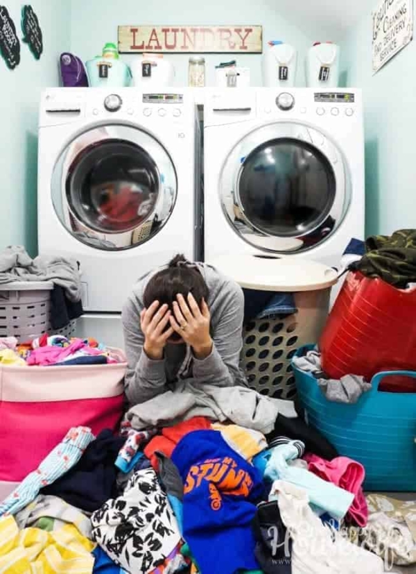 me overwhelmed with my head down in my hands sitting in a pile of laundry