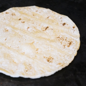 heating up corn tortillas on a skillet