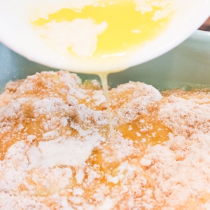 pouring butter on top of the apple crumble