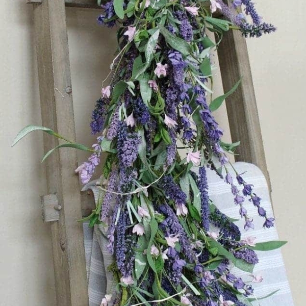 Lavender flower garland draped over a ladder.