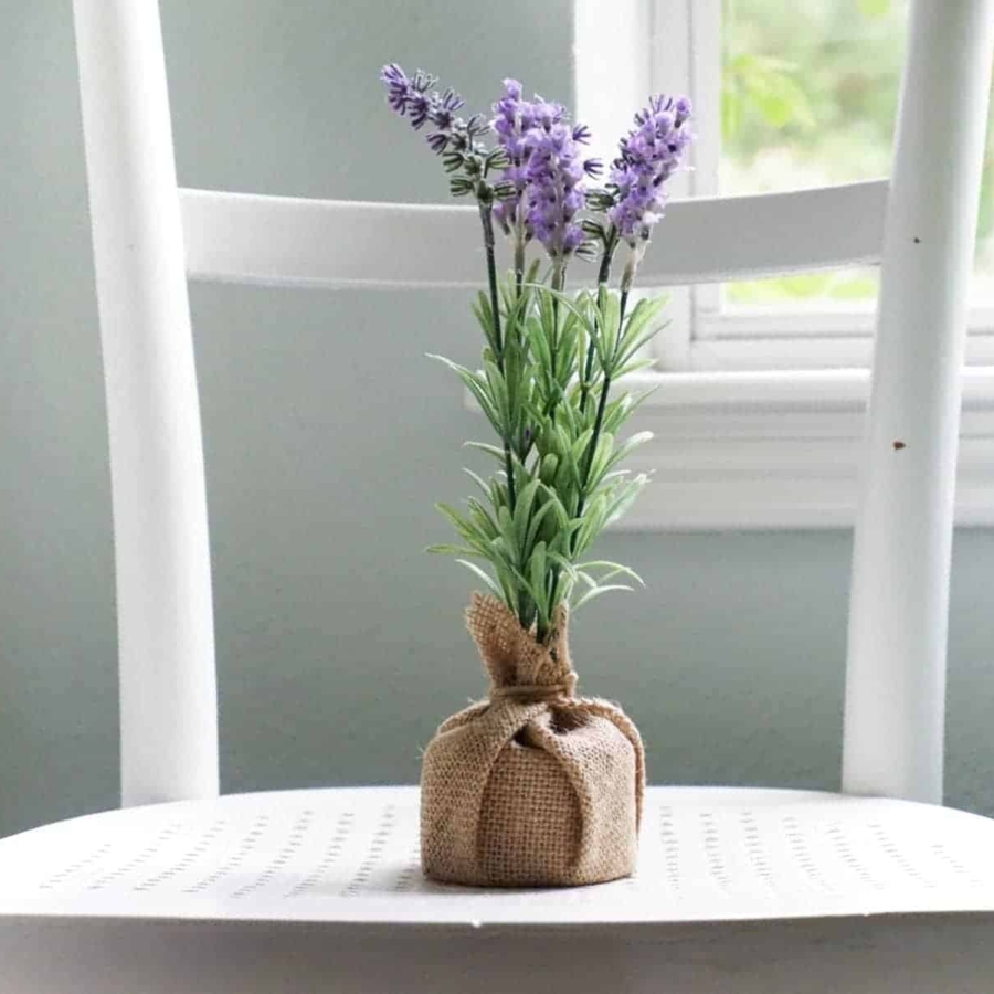 Lavender flowers in a burlap sack sitting on a chair.