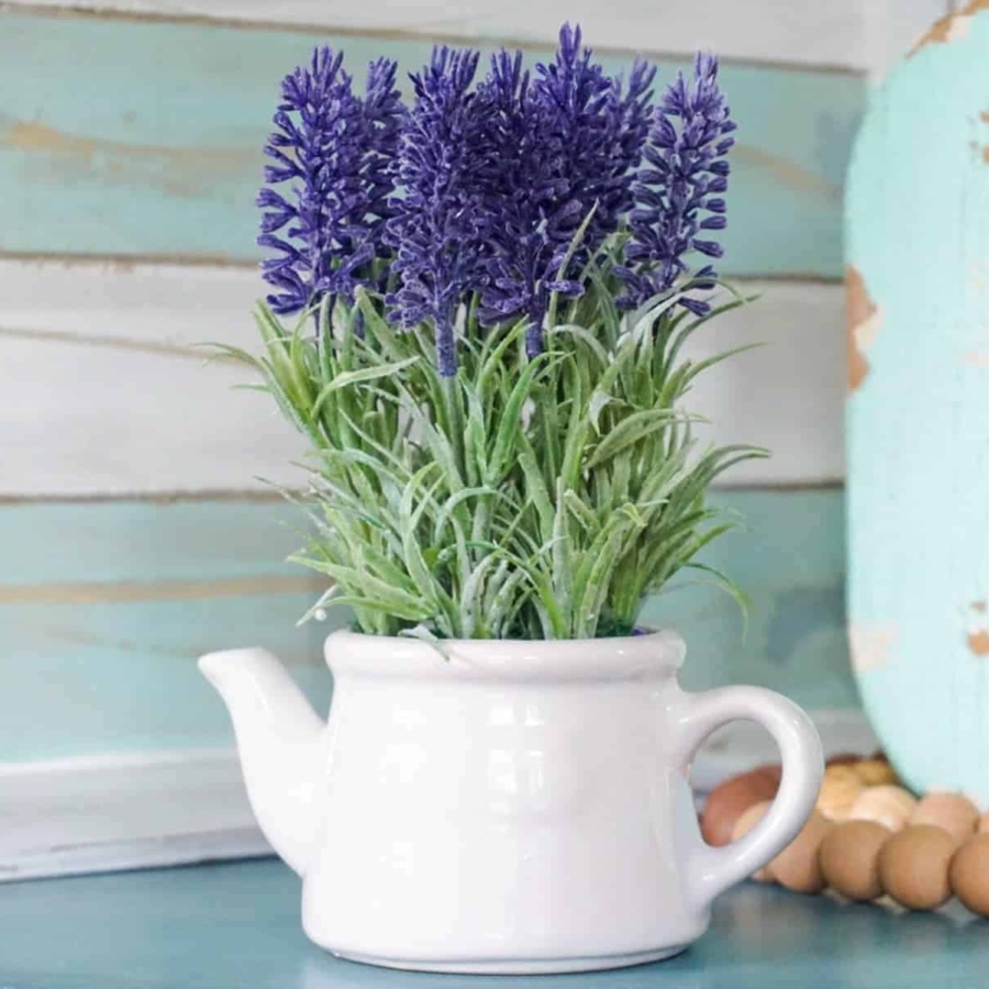 Lavender flowers in a white tin pitcher on the table.