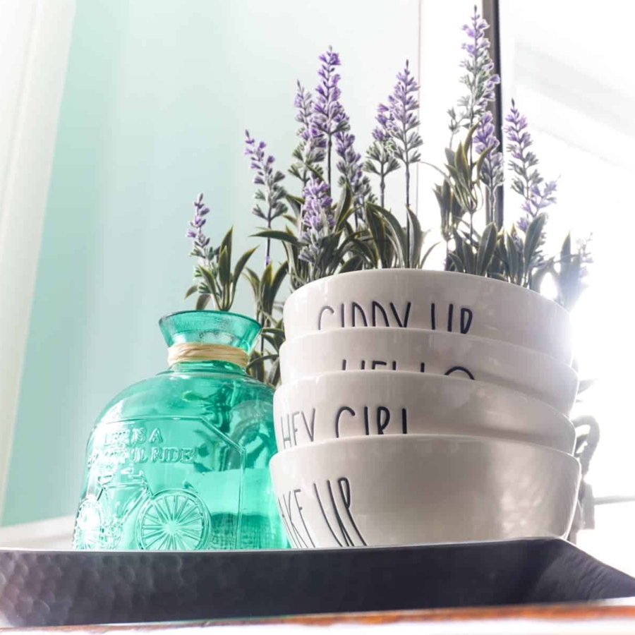 Placing lavender flowers and Rae Dunn on a tray help spruce up the dining room buffet.