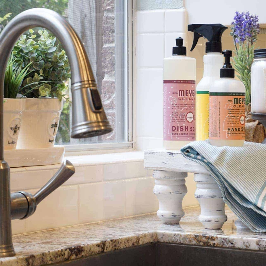 Lavender flowers and Mrs. Meyers on a wooden tray dress up the sink in the kitchen. 