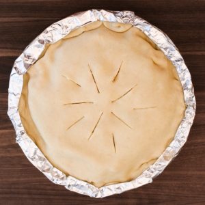 Protecting chicken pot pie edges with foil.