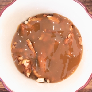 pecans mixed with caramel in a bowl