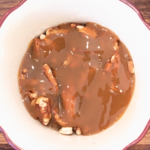 pecans mixed with caramel in a bowl