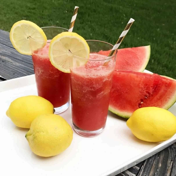 two cups of watermelon lemonade slush topped with a slice of lemon