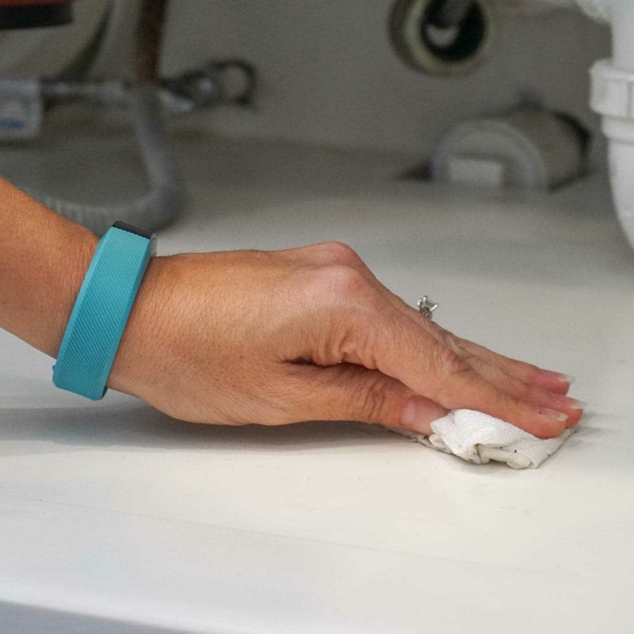 Cleaning and organizing under the sink.