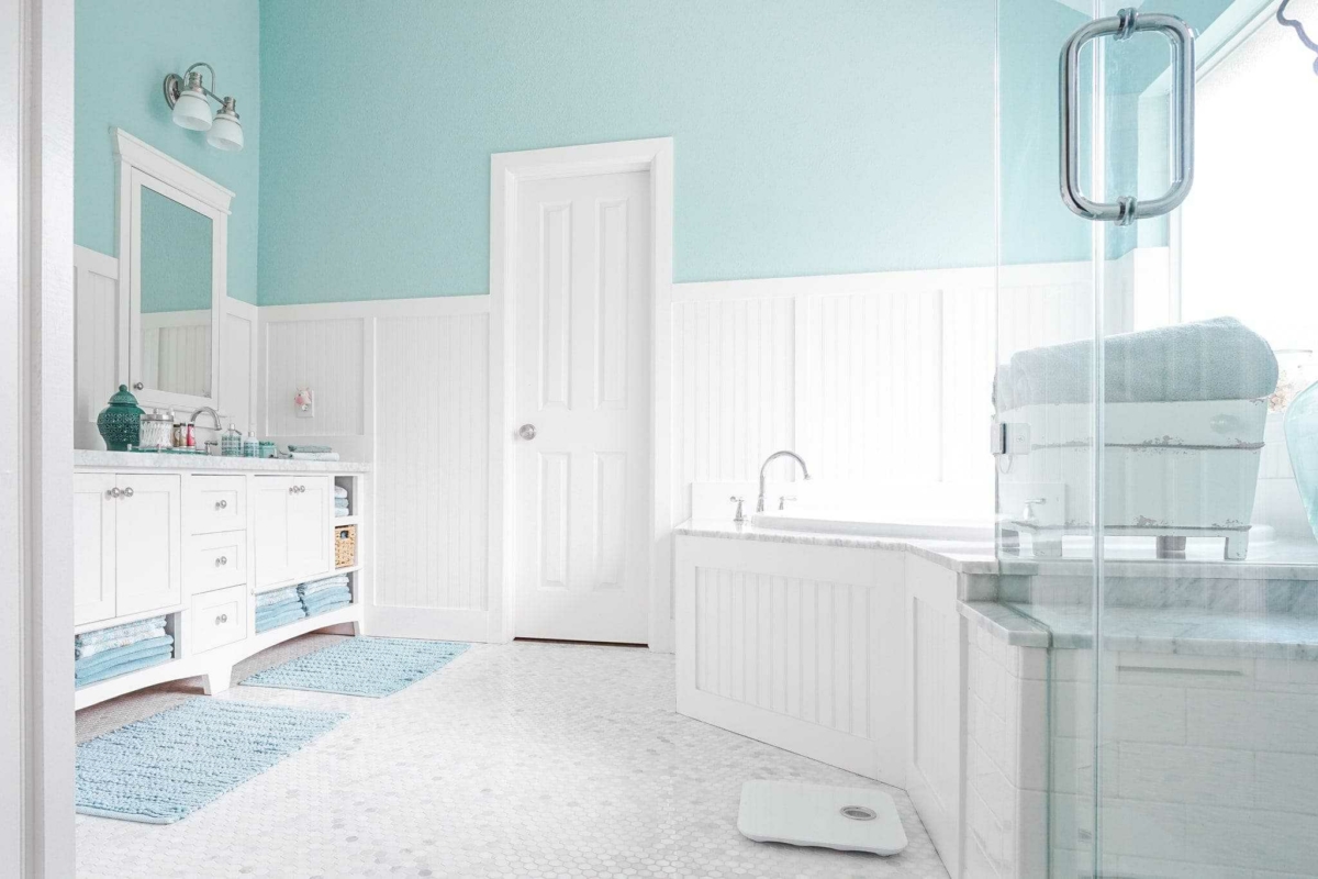 White tile and cabinets allow you to decorate your bathroom in any color scheme by swapping out bath mats and towels.