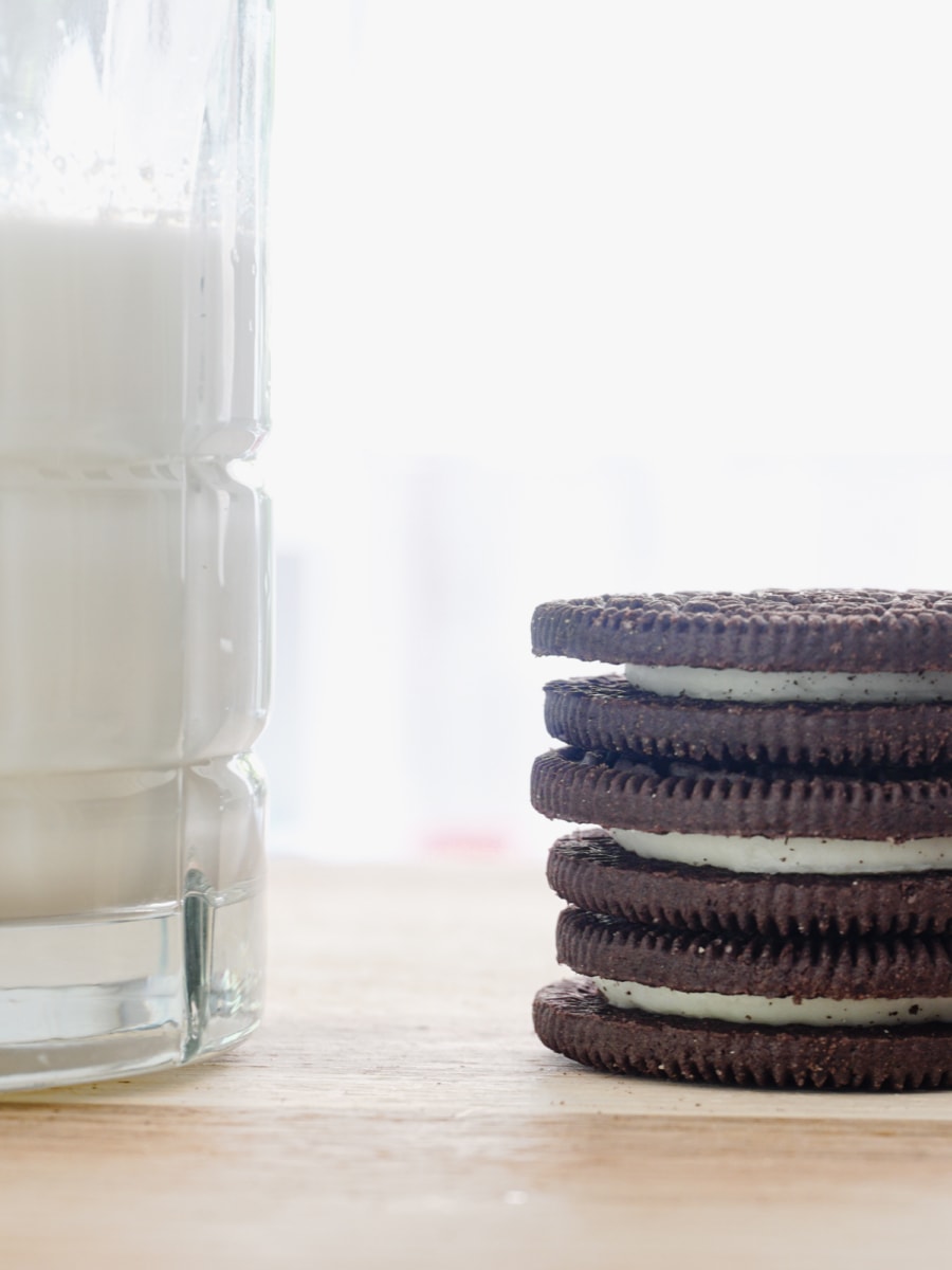 a glass of milk and three stacked oreos