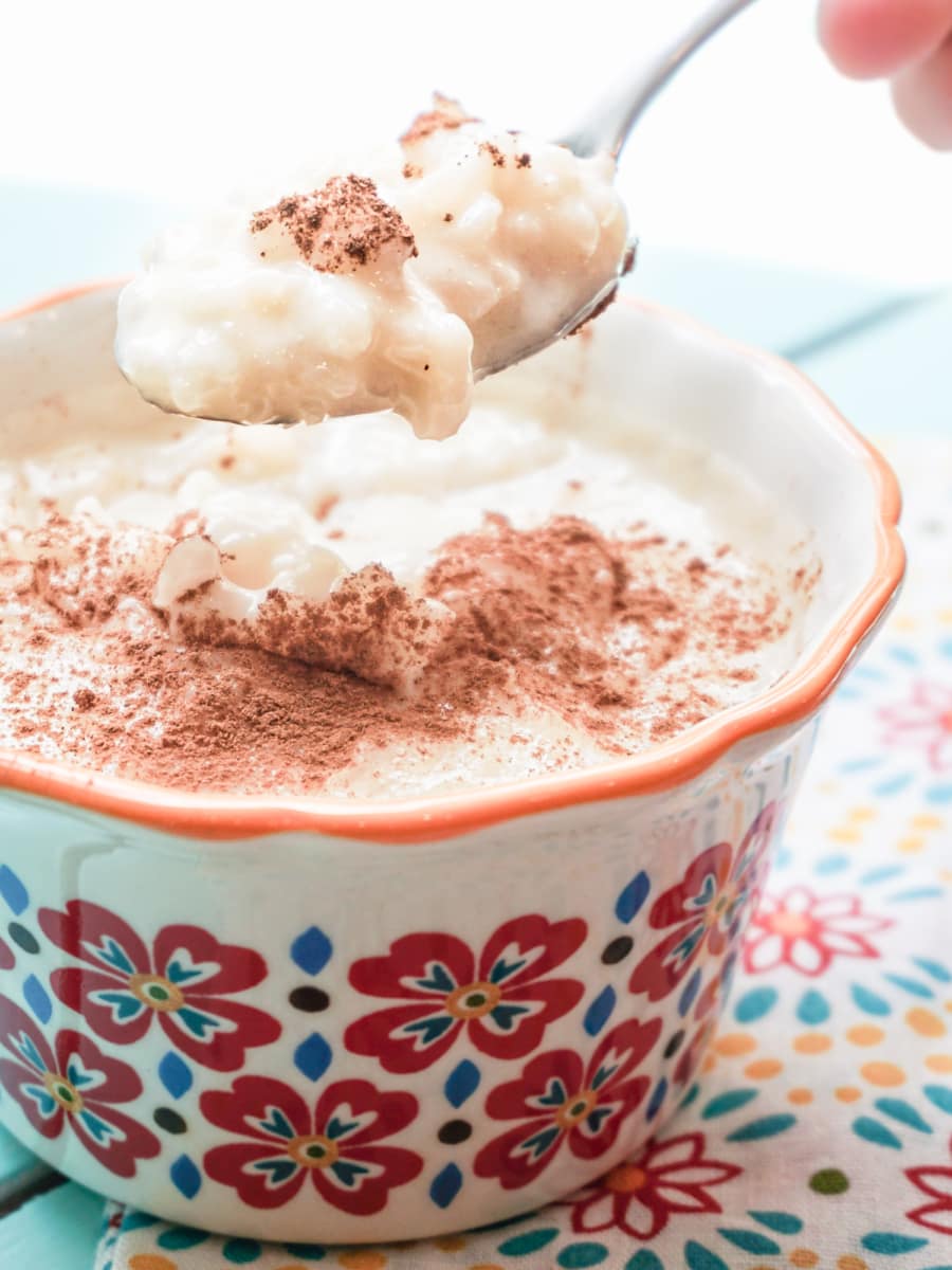 grabbing a spoonful of arroz con leche from a bowl