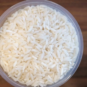 top view of uncooked white rice in a plastic cup