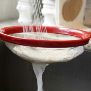 rinsing rice in a strainer over the sink