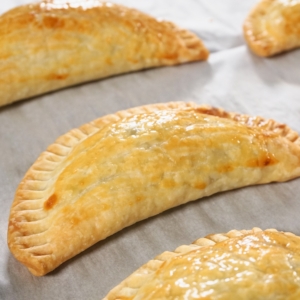 Beef and potato empanadas fresh out of the oven on a tray