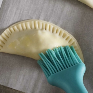 Brushing the beef and potato empanadas with egg