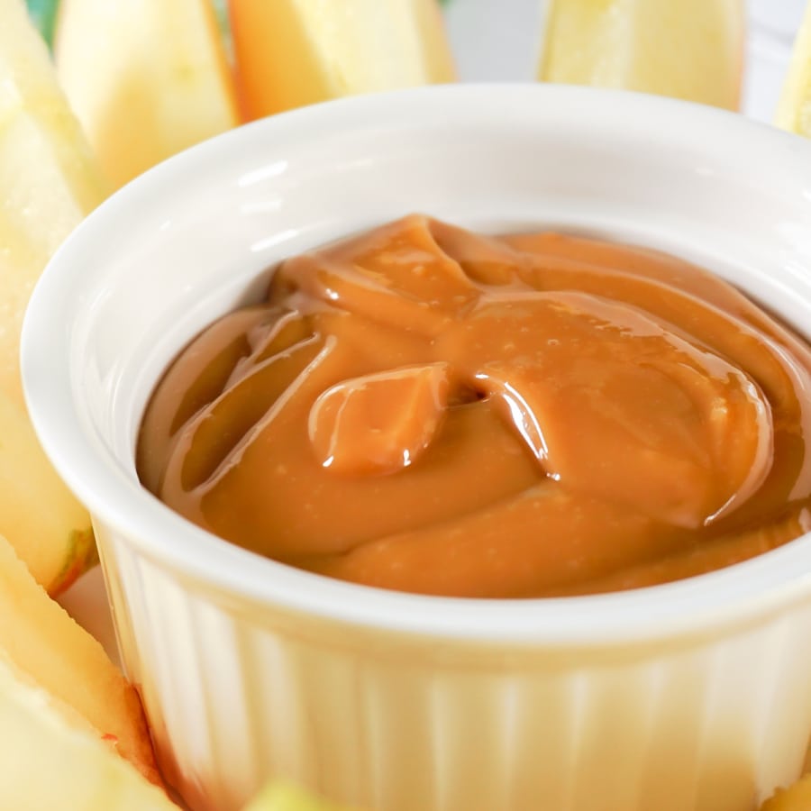 close up of apple slices on a plate with a small bowl of dulce de leche