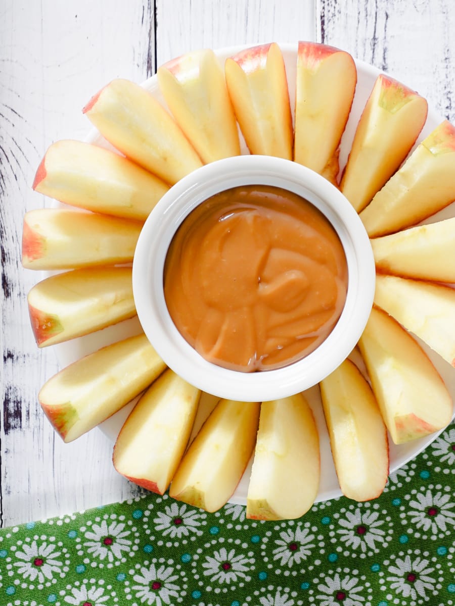 overhead shot of apple slices and dulce de leche served on a plate