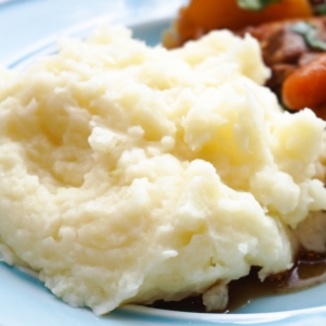 a plate with a serving of mashed potatoes and pot roast