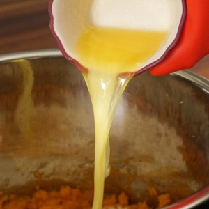 Adding melted butter to the sweet potatoes.