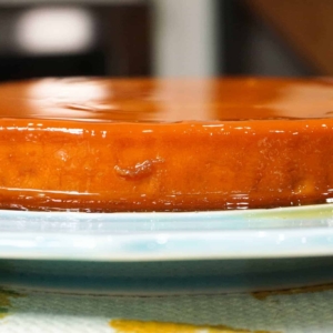 side view of a whole flan on an aqua plate