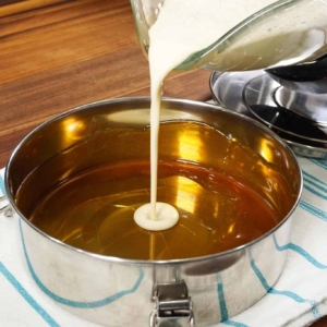 adding condensed milk to flan pan