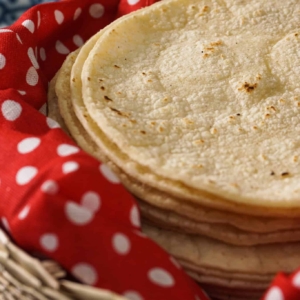 a stack of corn tortillas ready to be made into authentic mexican pork tacos