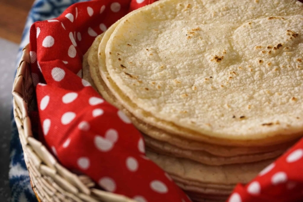a stack of corn tortillas ready to be made into authentic mexican pork tacos