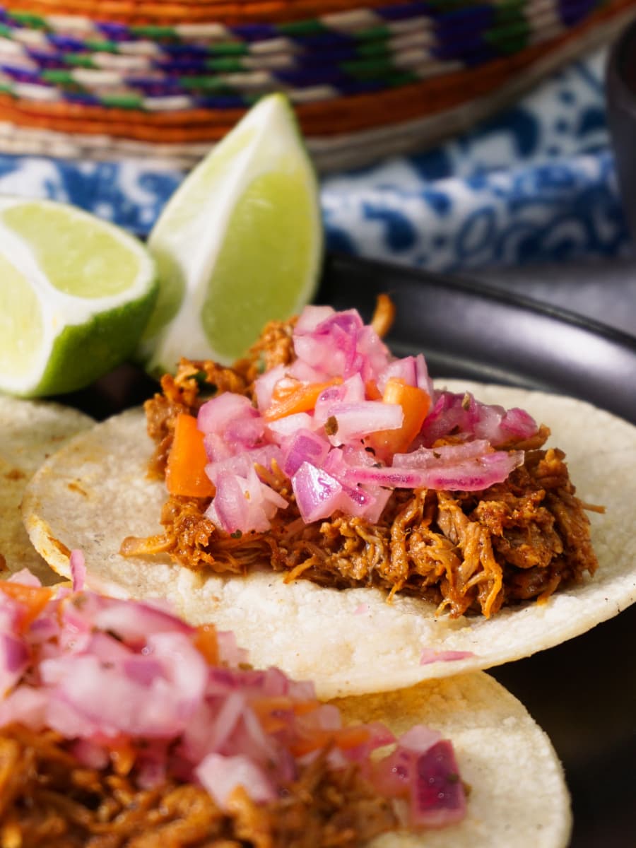 three mexican tacos served on flour tortillas with cochinita pibil and habanero salsa