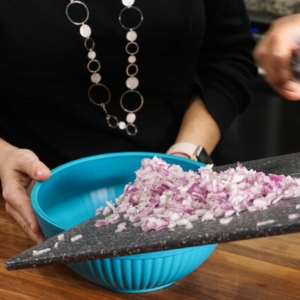 adding chopped red onion to a prep bowl for this homemade habanero salsa recipe