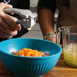 mincing garlic while showing how to make salsa de habanero