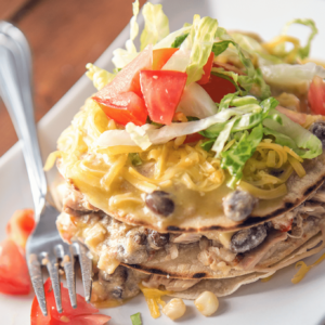 a square dish with chicken enchiladas