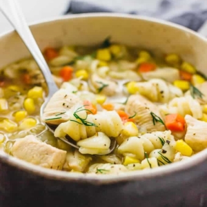 a spoonful of chicken noodle soup in a bowl