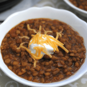 lentil chili topped with sour cream and shredded cheese