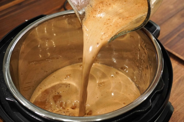 adding the sauce to the instant pot for this pork roast recipe