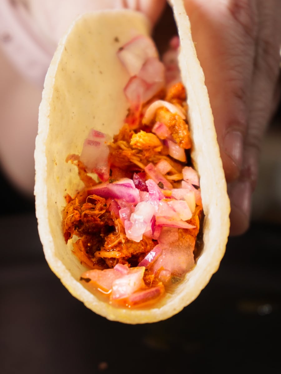 holding a cochinita pibil pork taco