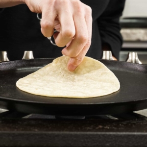 heating up corn tortillas on the skillet for this cochinitas pibil pork tacos recipe