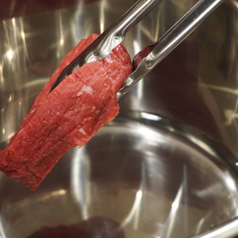 placing the meat in the pot to make salpicon, one of the best eye of round recipes for the instant pot