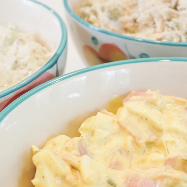 a bowl of cream cheese dip on a plate surrounded with bread crackers