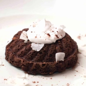 a paleo chocolate cake topped with whipped cream