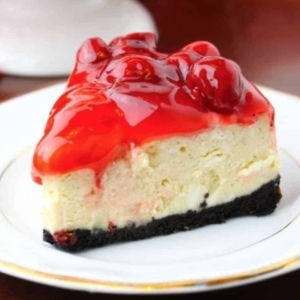 a small plate with a slice of a creamy cherry cheesecake